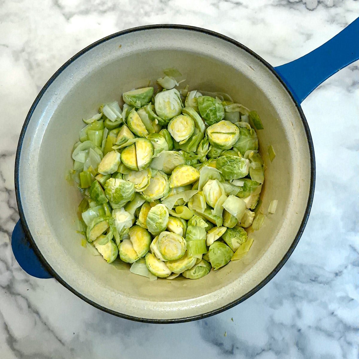 Sliced brussels sprouts added to the saucepan.