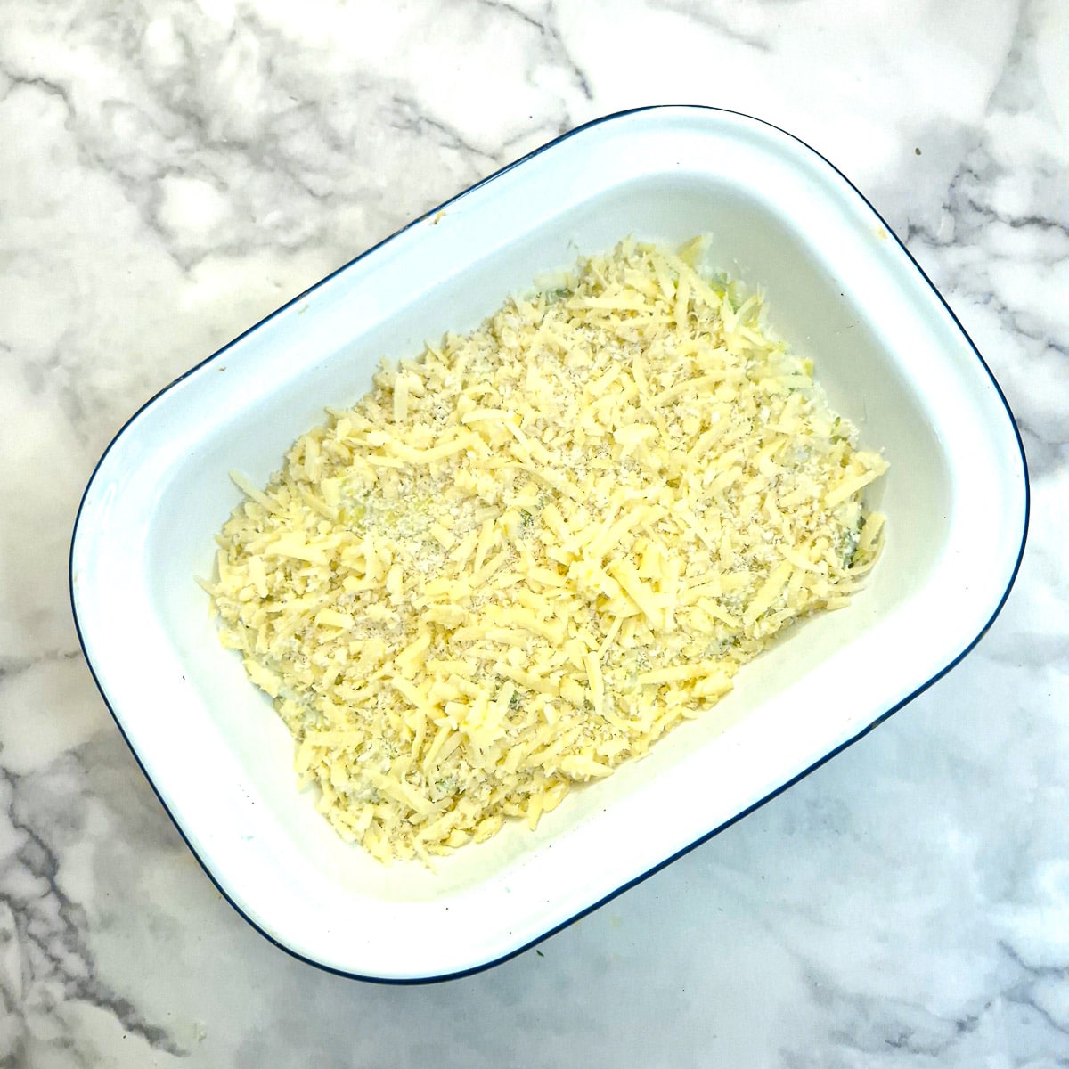 Grated cheese and breadcrumbs spread on top of the casserole.