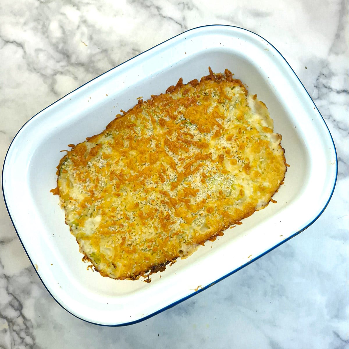 A fully cooked dish of creamy leek and brussels sprouts au gratin.