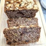 Close up of slices of honey oat apple and banana loaf on a wooden board.