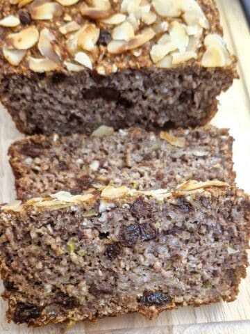 Close up of slices of honey oat apple and banana loaf on a wooden board.