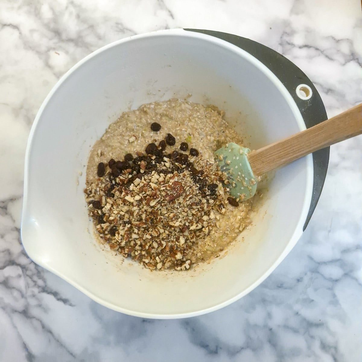 Chopped pecan nuts and raisings being added to the batter.