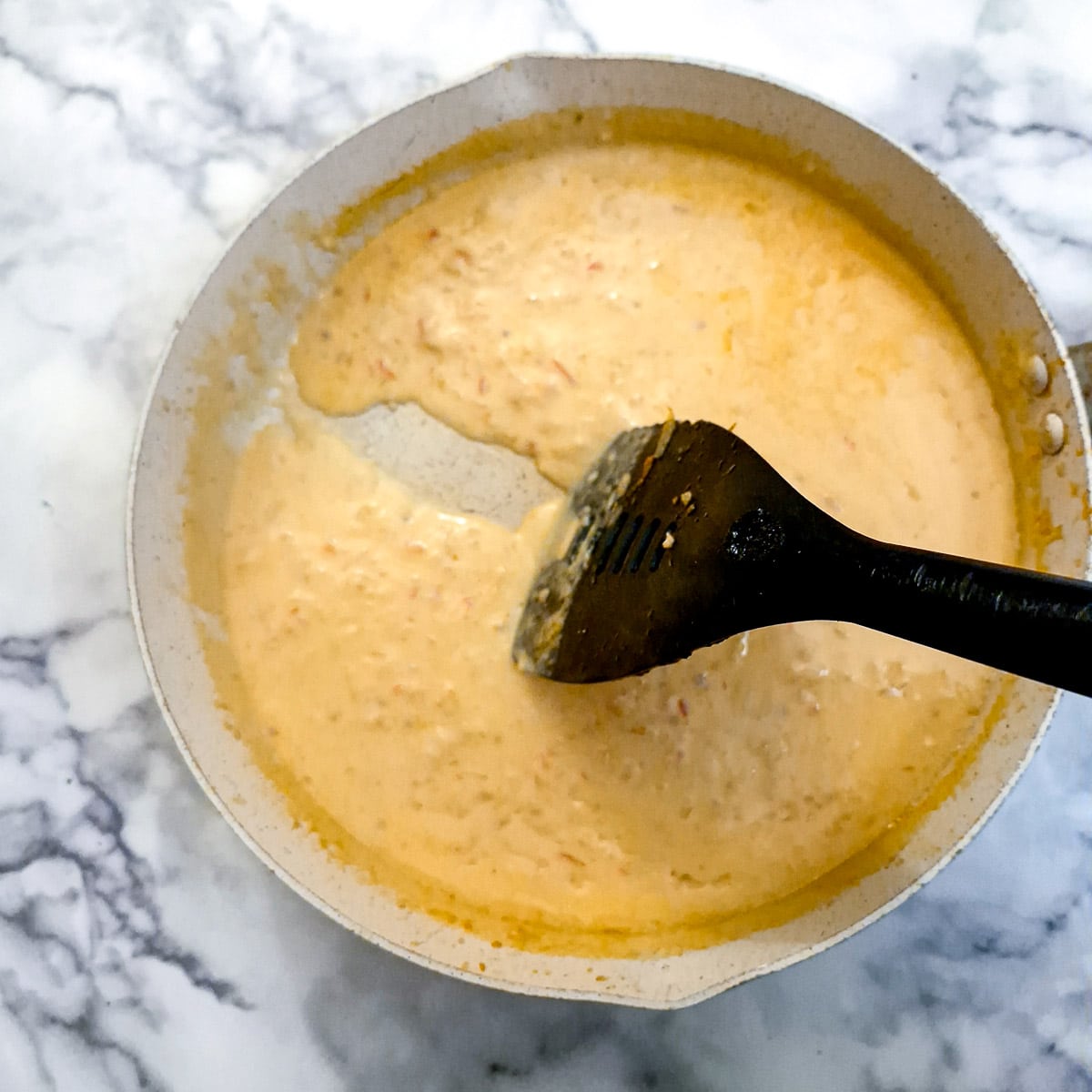 A spoon leaving a trail when drawn through the sauce to show the consistency.