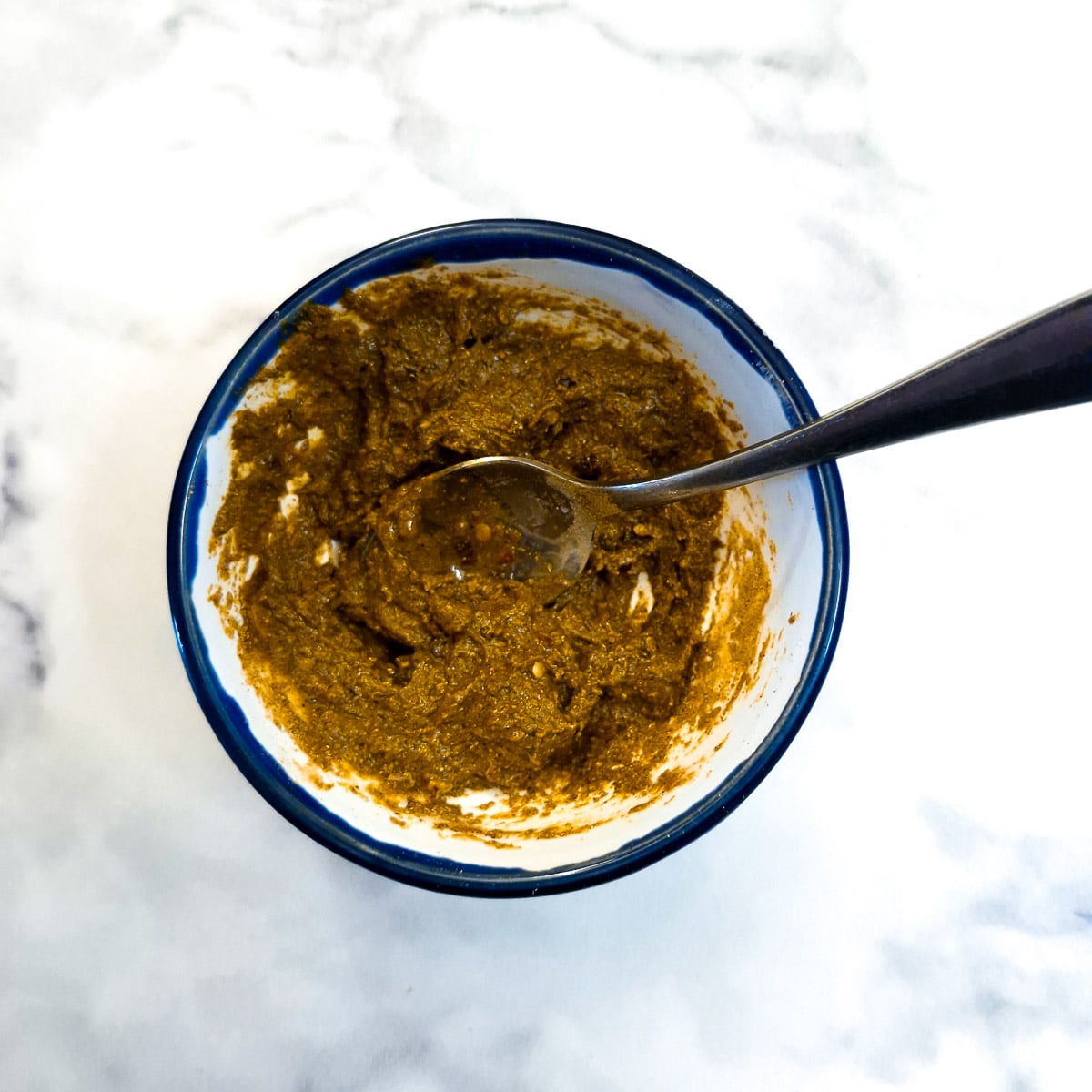 Fruit chutney and spices combined in a small bowl.