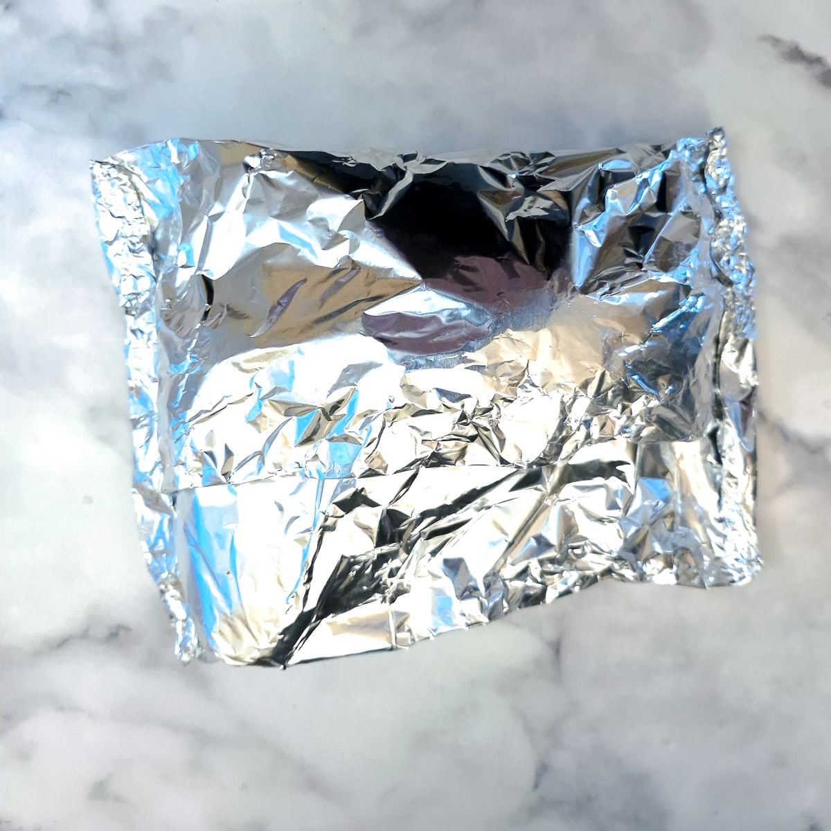 A tin foil-wrapped leg of lamb.