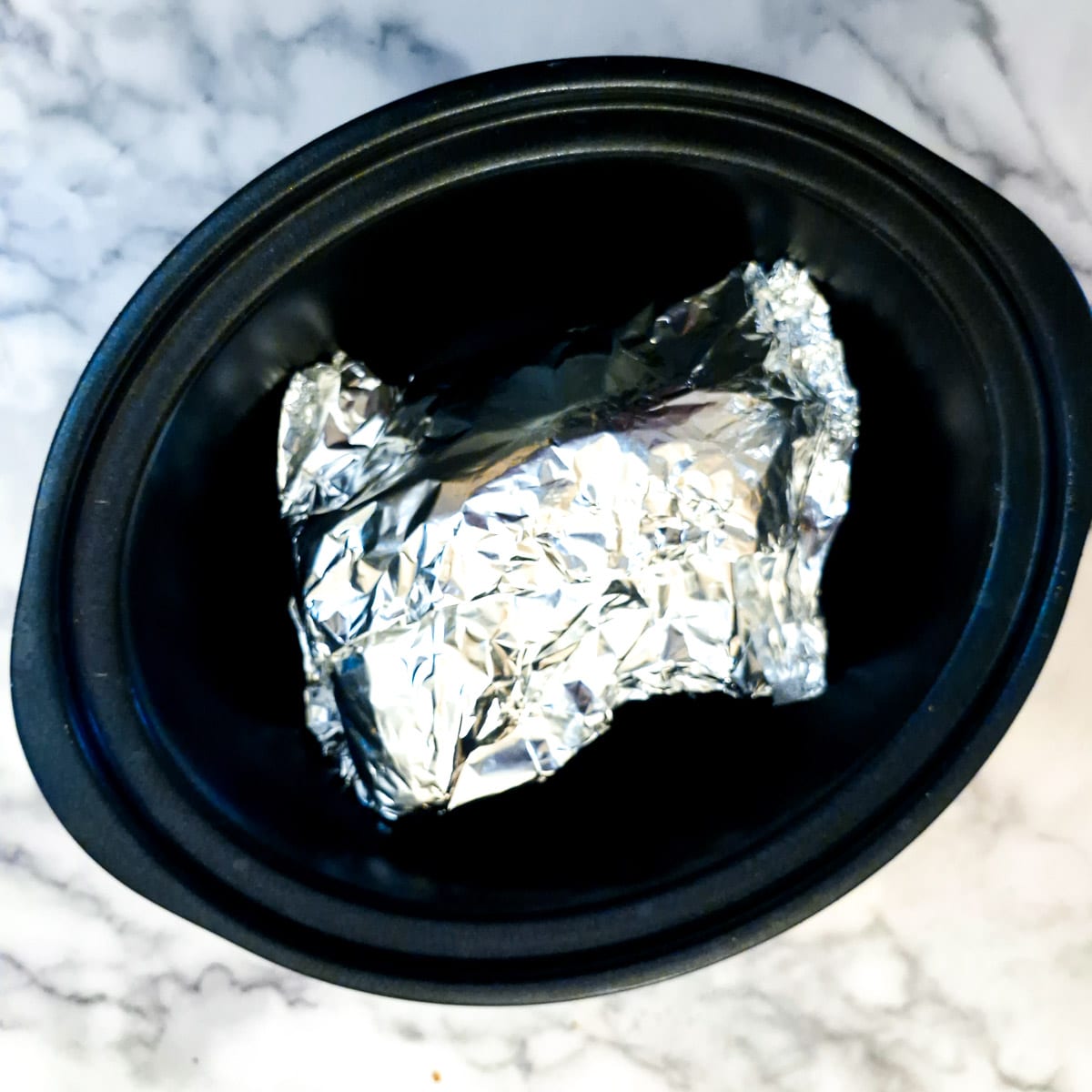 Foil-wrapped leg of lamb in the slow cooker.