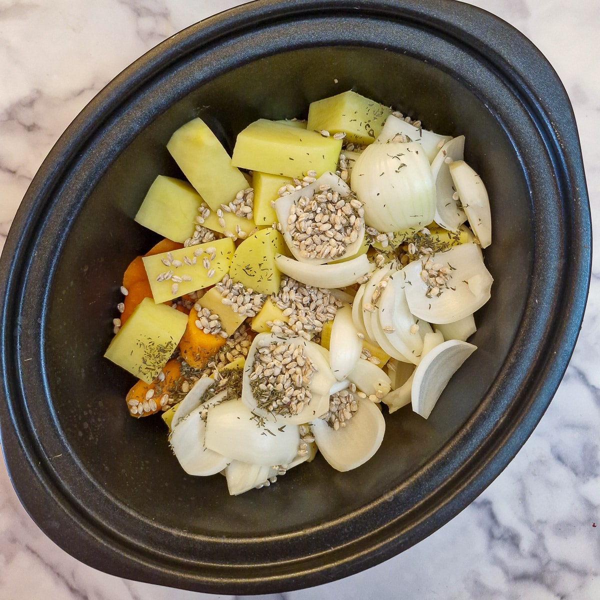 Vegetables and barley in a slow cooker.