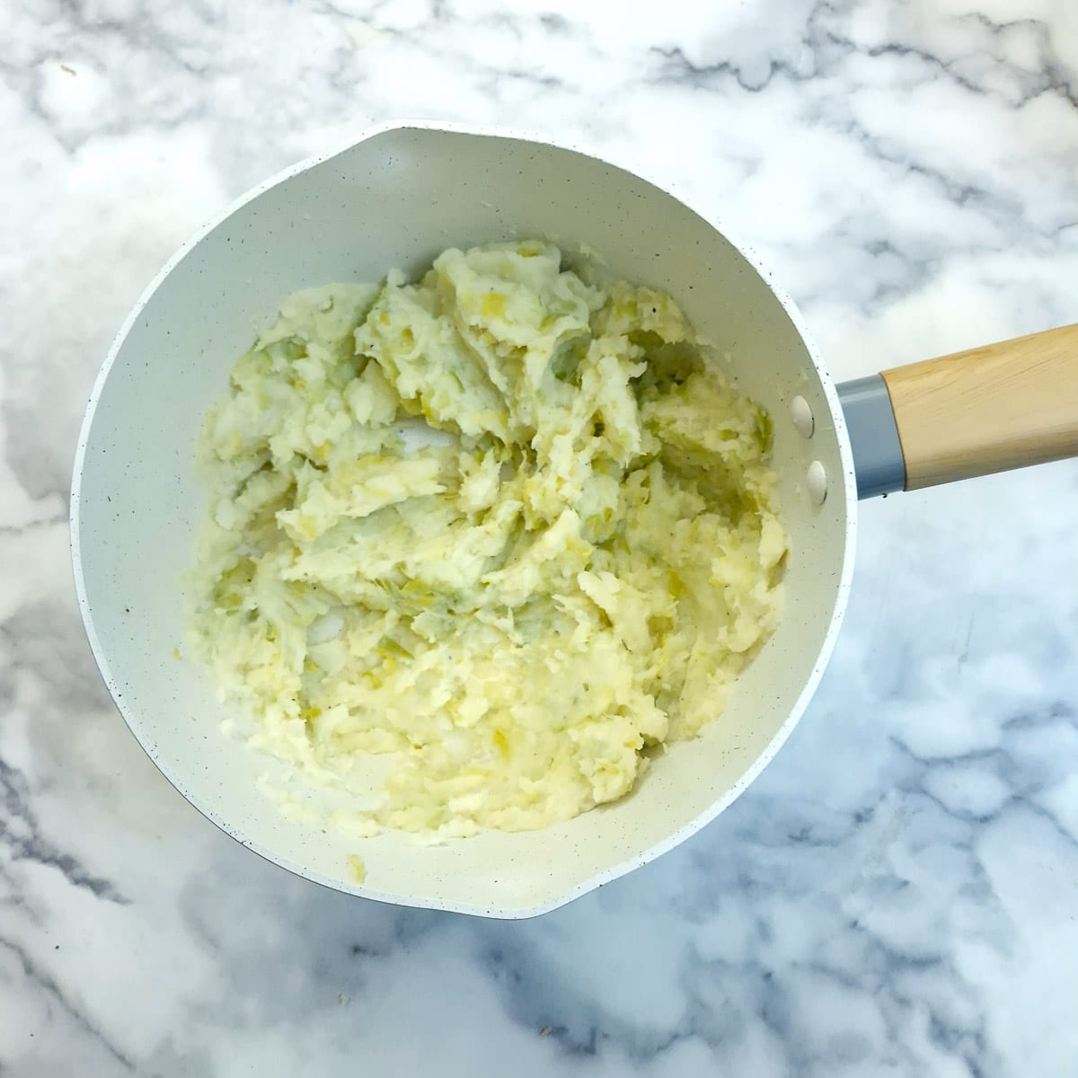 Mashed leeks and potatoes in a saucepan.