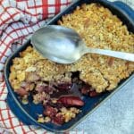 Overhead shot of apple and blackberry crumble with one corner removed.