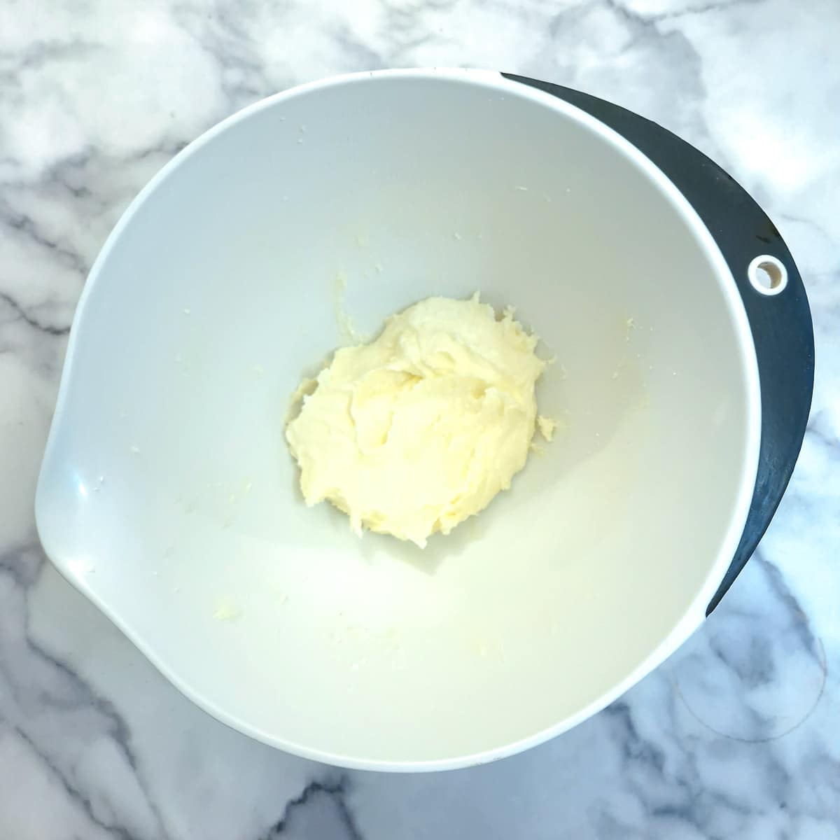 Butter and sugar creamed together in a mixing bowl.