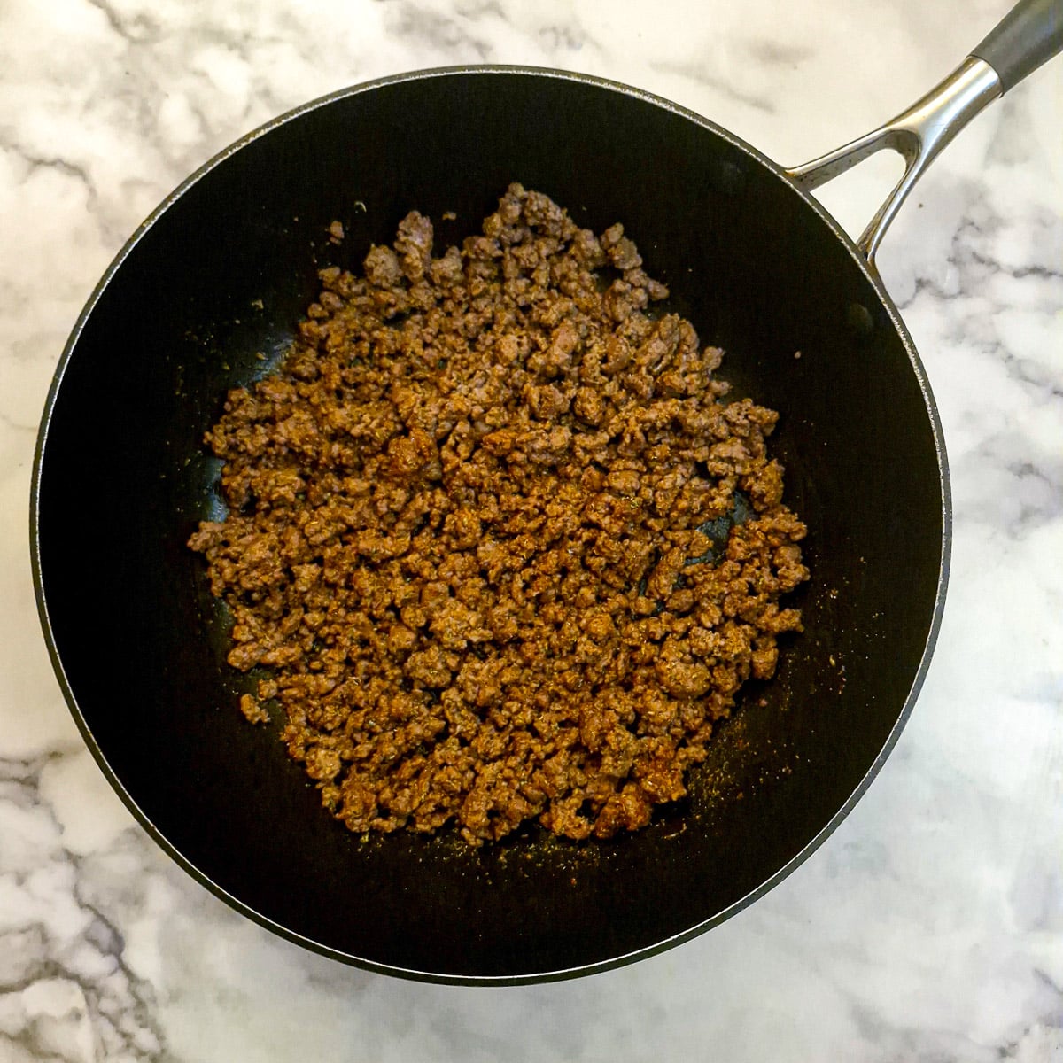 Browned ground beef in a frying pan.