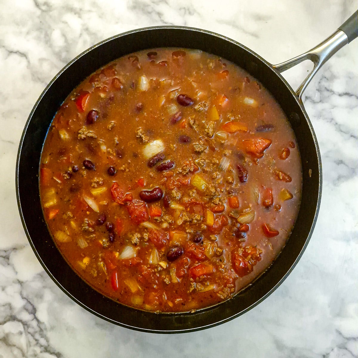 Rice, stock and tomatoes added to the meat and vegetables.