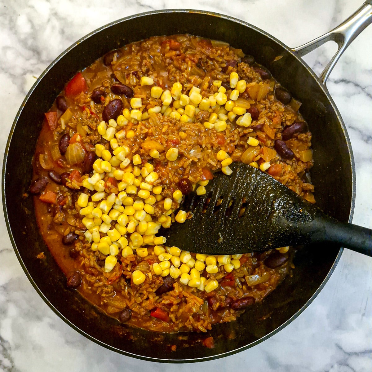 Corn being added to the casserole.