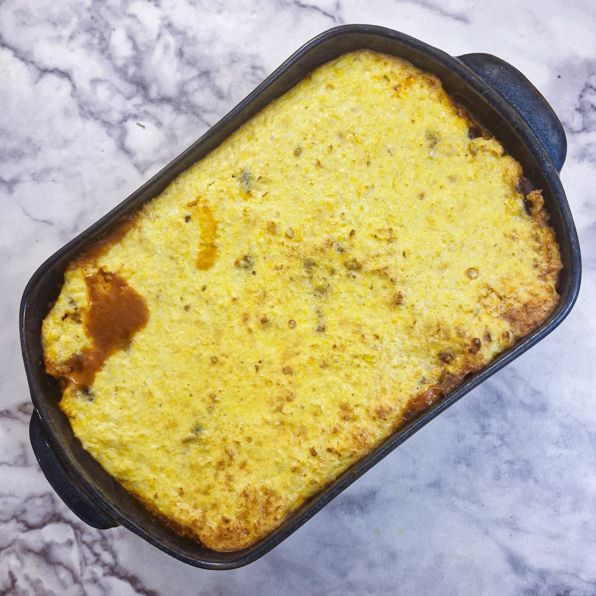 Baked chilli con carne rice casserole in a blue dish.