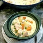 A dark green soup bowl filled with creamy salmon chowder.
