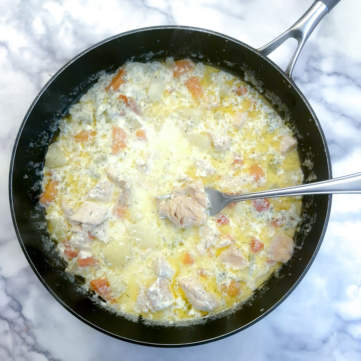 Salmon pieces poaching in the chowder.