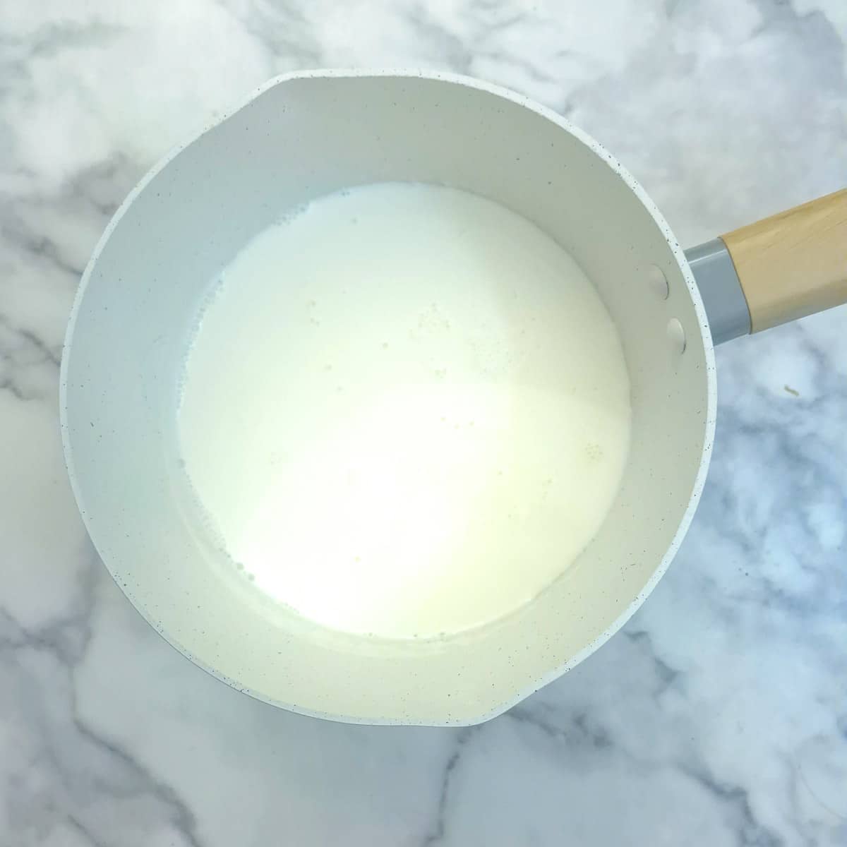 A saucepan containing hot milk.
