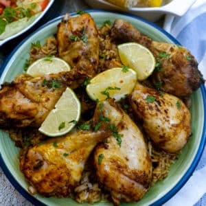 A green dish of peri peri chicken drumsticks.