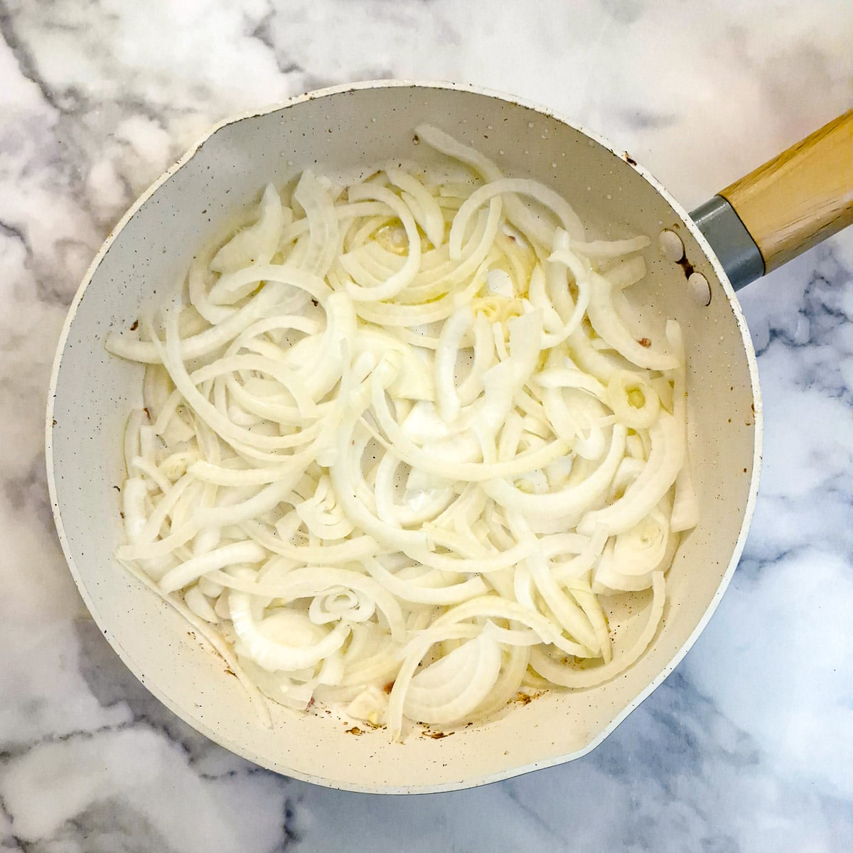 Sliced onions in a frying pan.