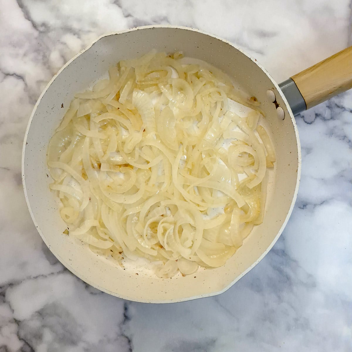 Softened slice onions in a frying pan.