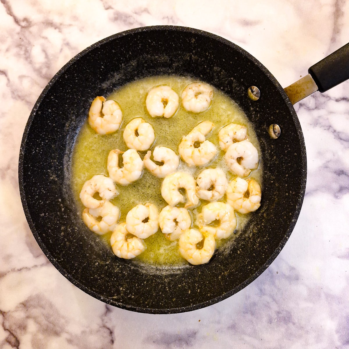 Prawns being sauteed in butter.