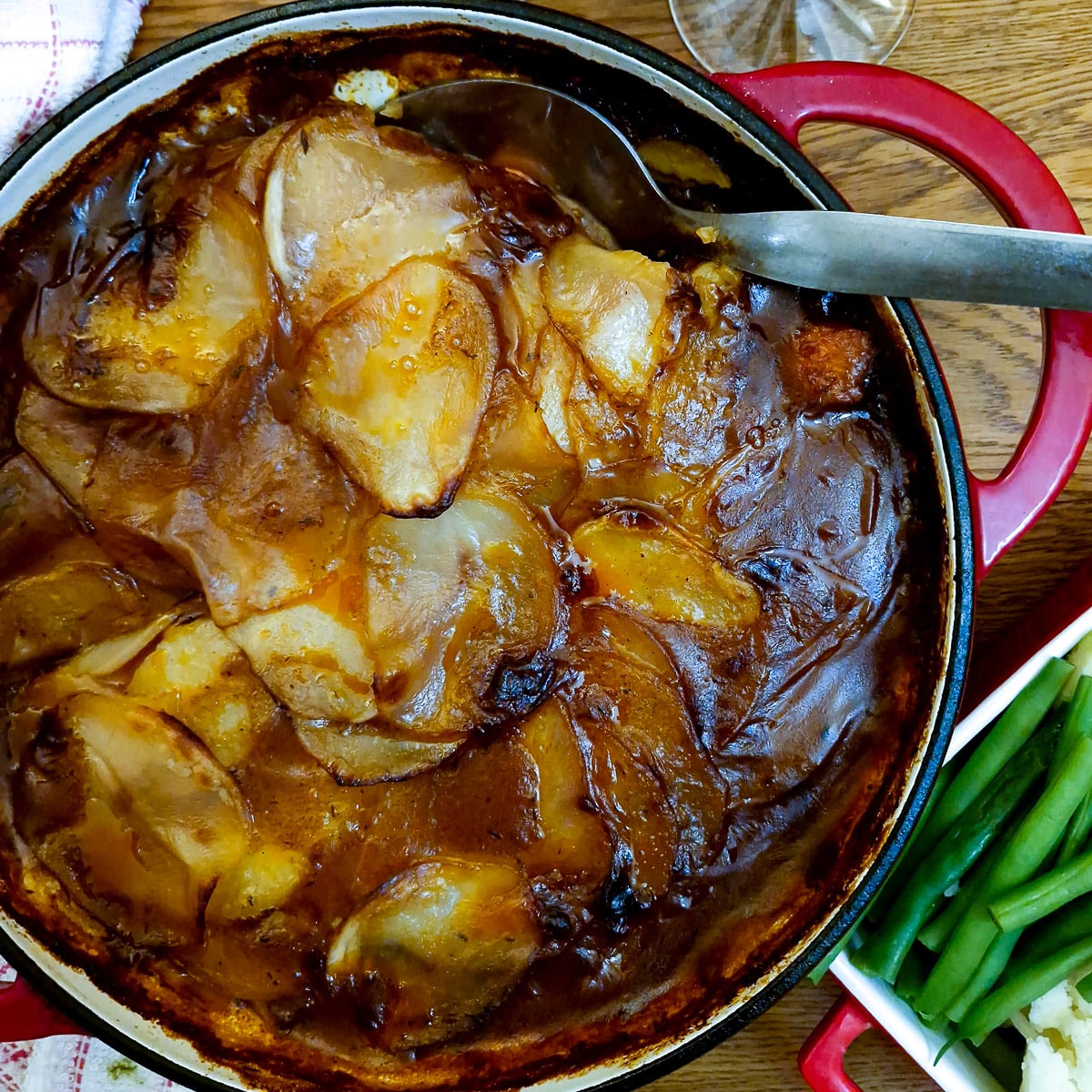 Steak and kidney hotpot in a casserole dish with lots of gravy.
