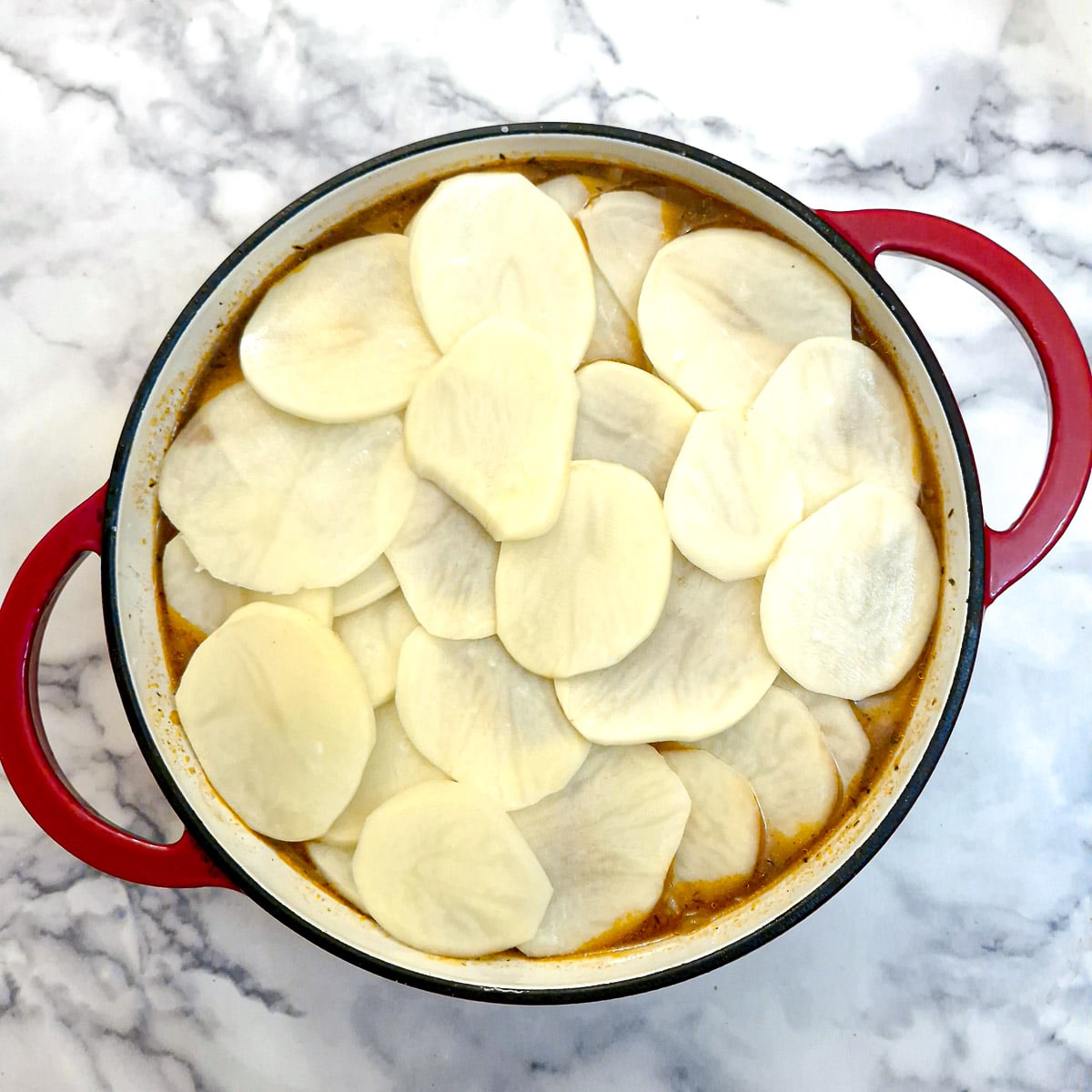 Sliced potatoes arranged on top of the filling.