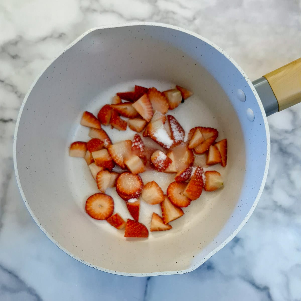 Chopped up strawberries in a saucepan.