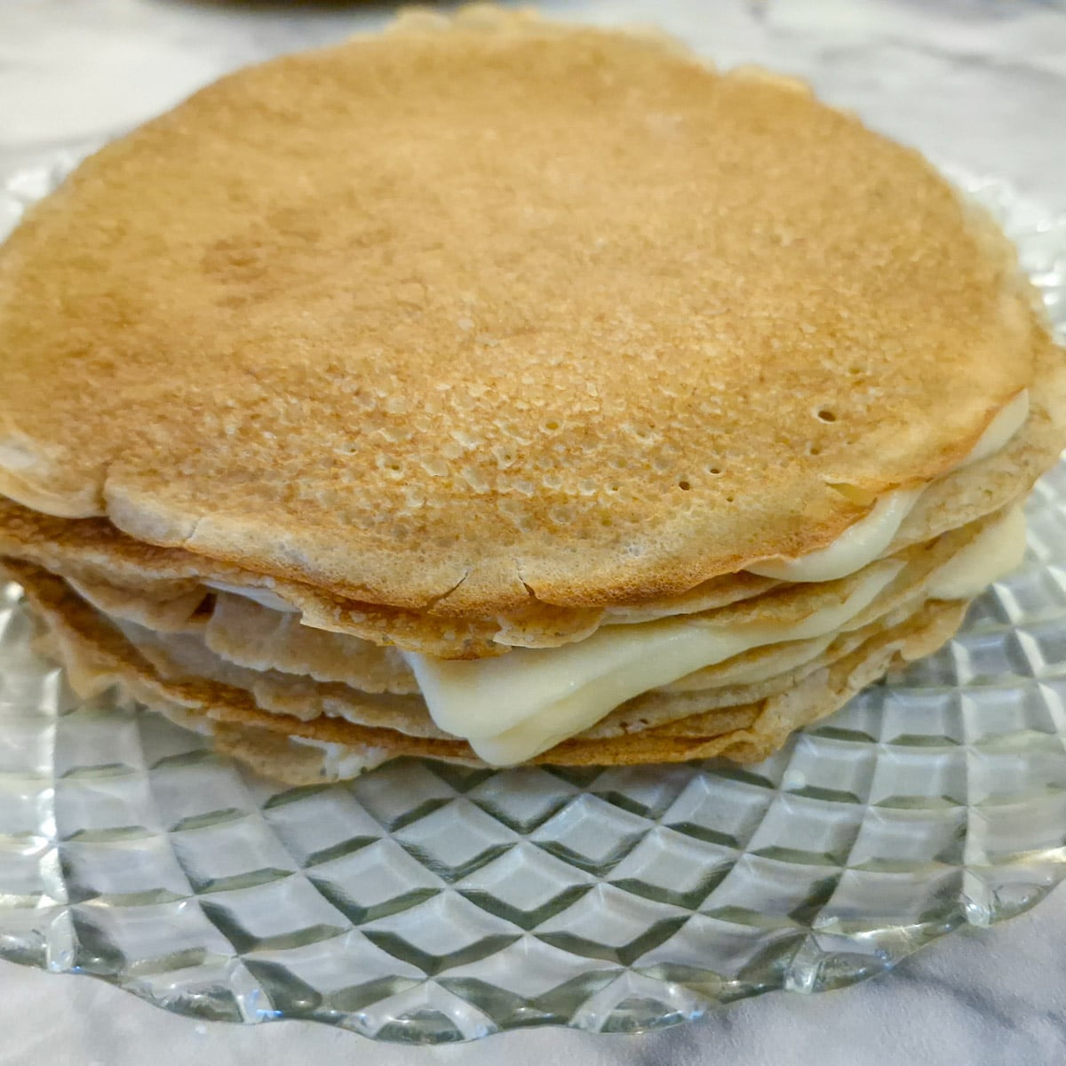 Side-on view of pancakes layered with custard.