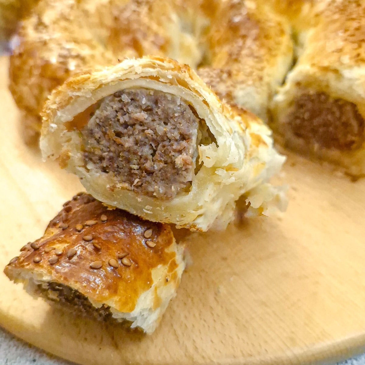 Close up of a boerewors puff pastry spiral showing the flaky puff pastry and the thick juicy meat filling.