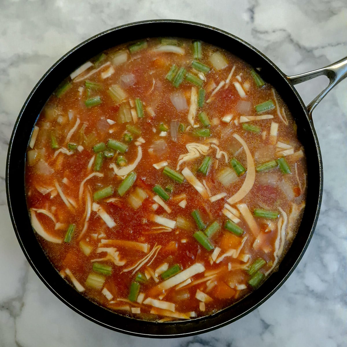 Cabbage, green beans, tomatoes, baked beans and water added to the minestrone.