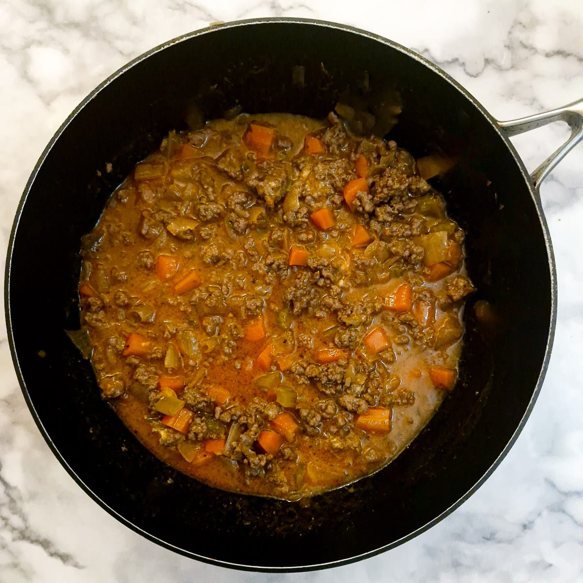 Thickened meat pie filling in a frying pan.