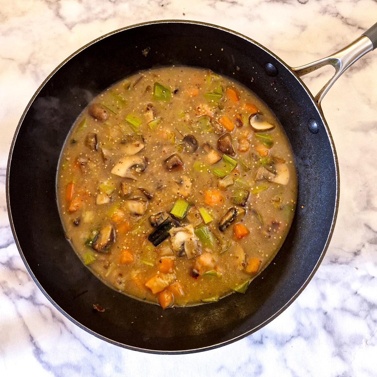 Stock and mustard stirred into the vegetables and flour.