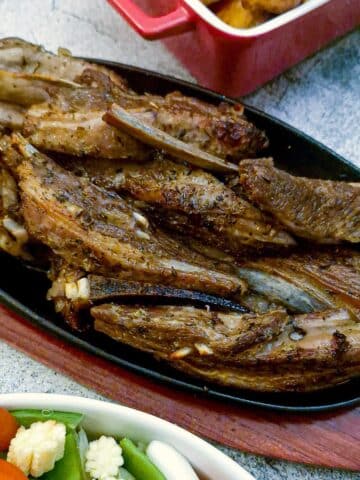 Lamb ribs on a wooden serving dish.