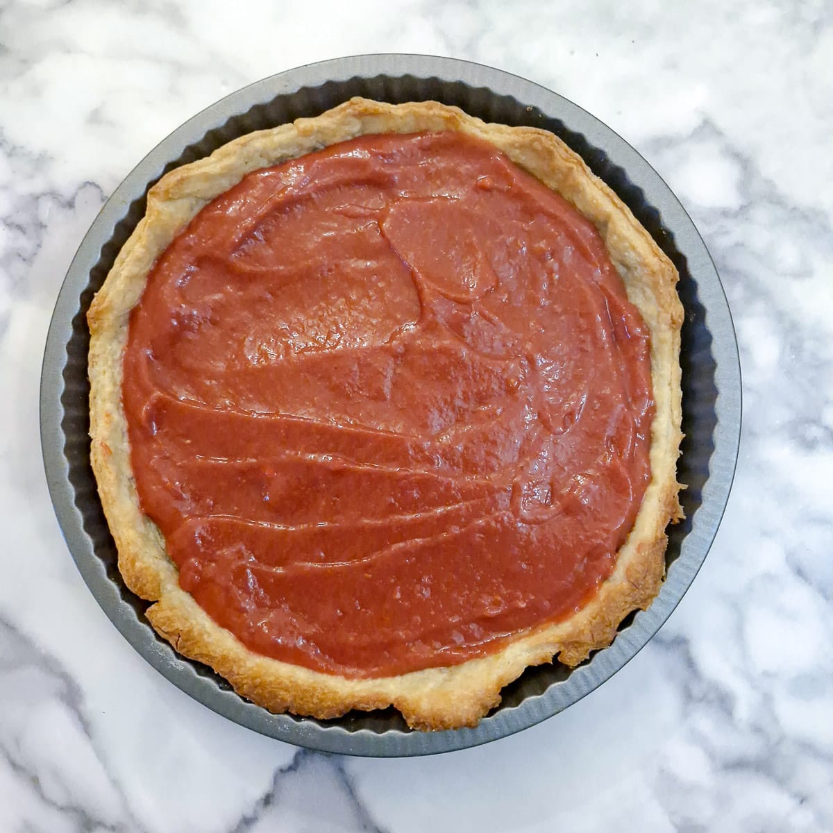 A pastry shell filled with raspberry curd.