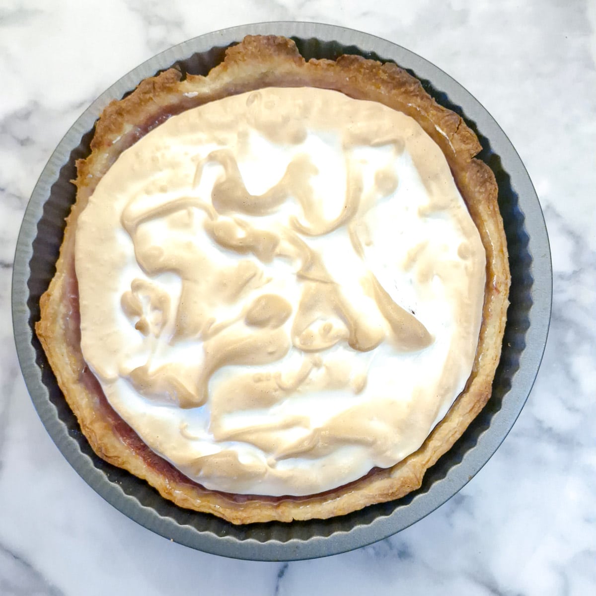 A nicely browned cooked raspberry meringue pie.