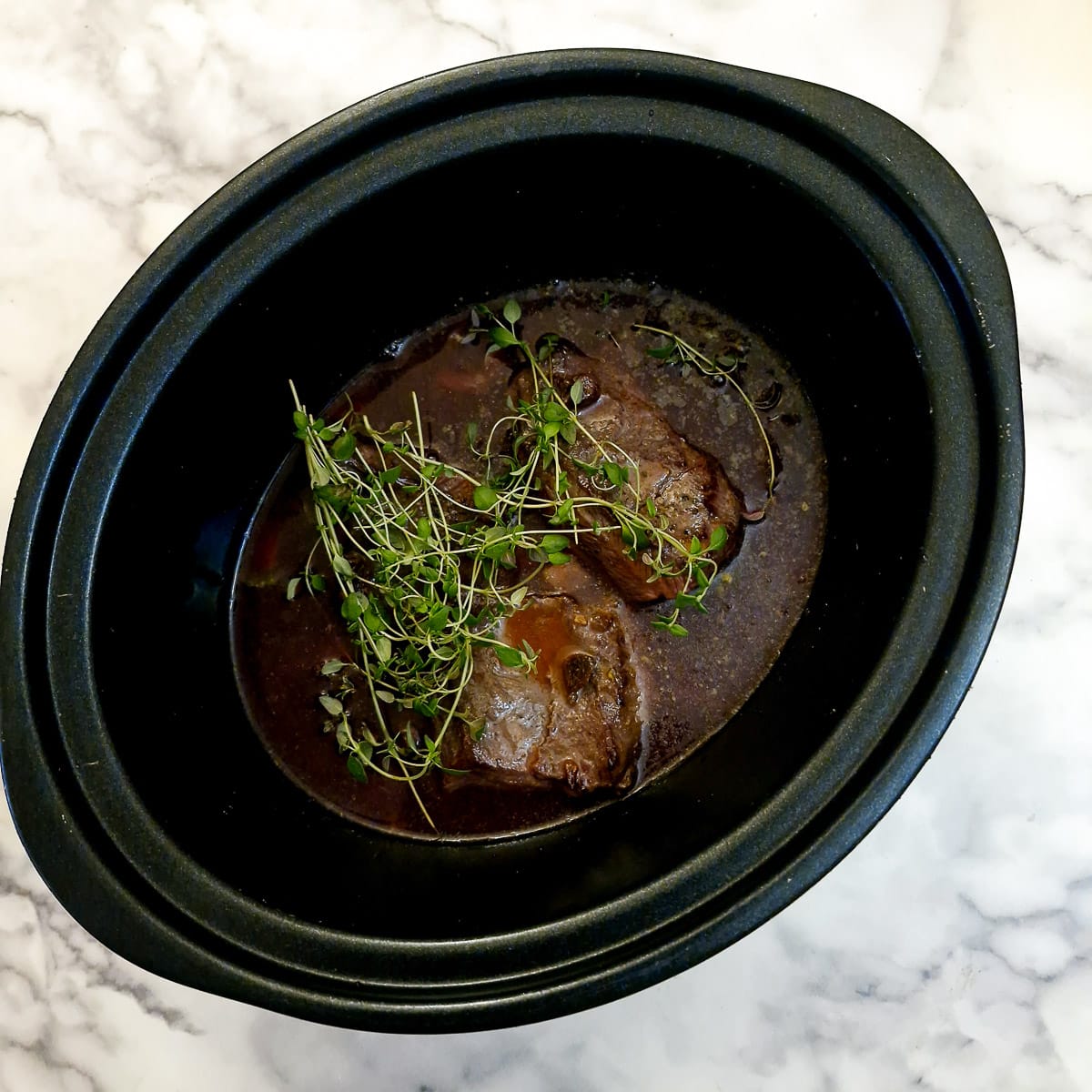 Stock and fresh thyme added to the slow cooker.