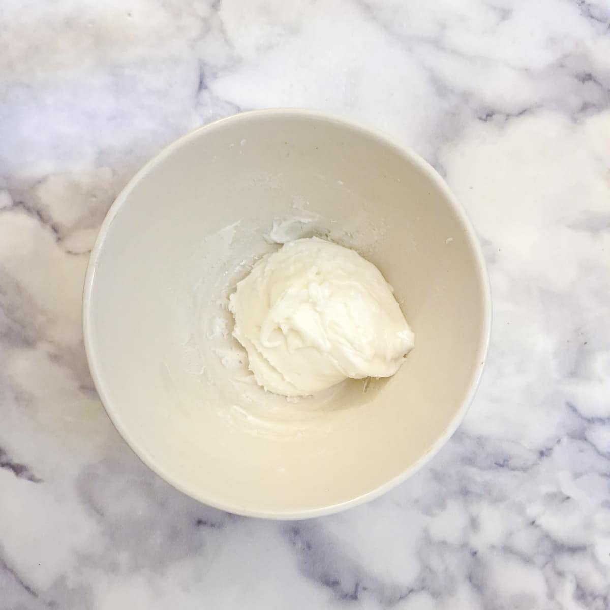 Egg white and icing sugar mixed to a thick paste in a small mixing bowl.