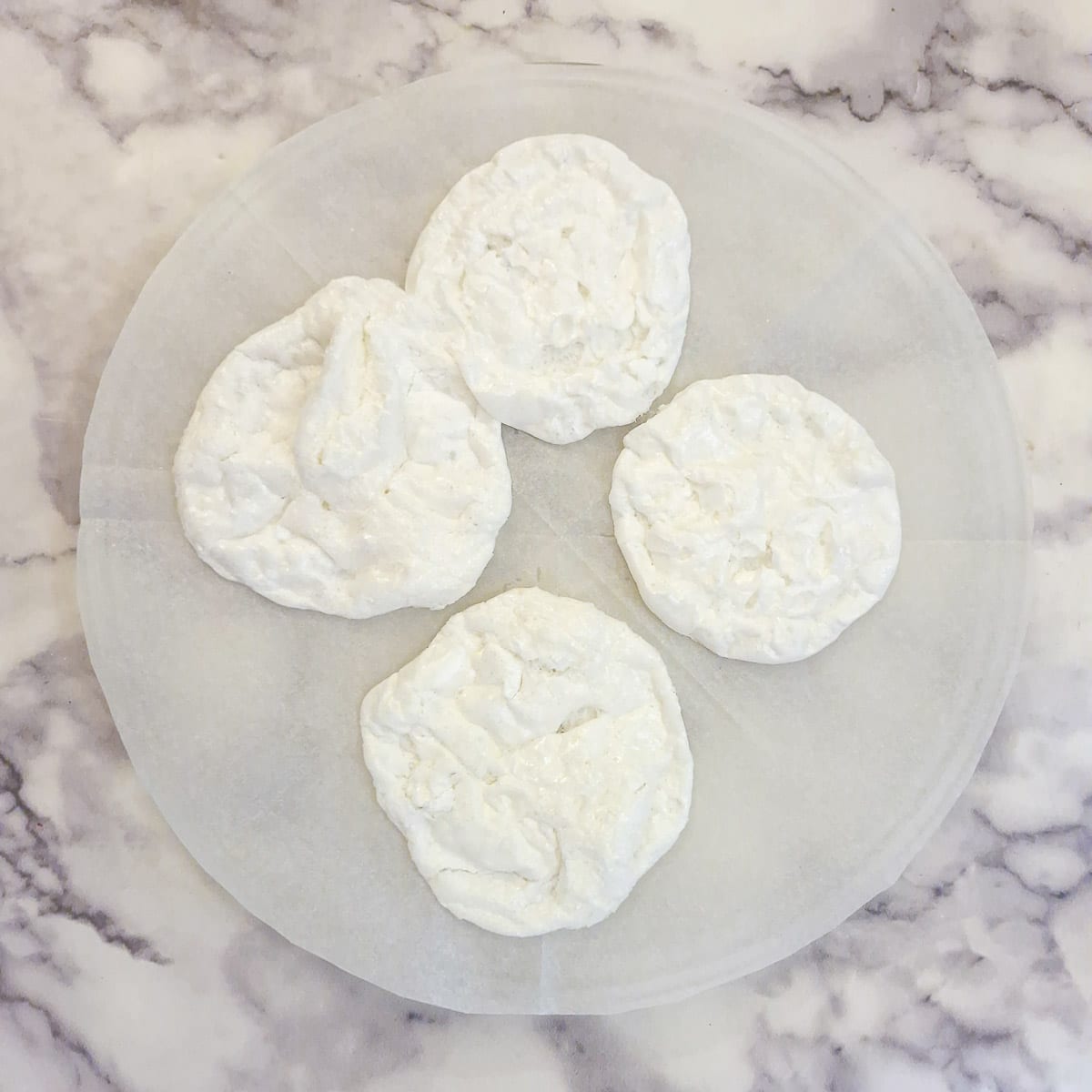 4 microwaved meringues on a microwave plate.