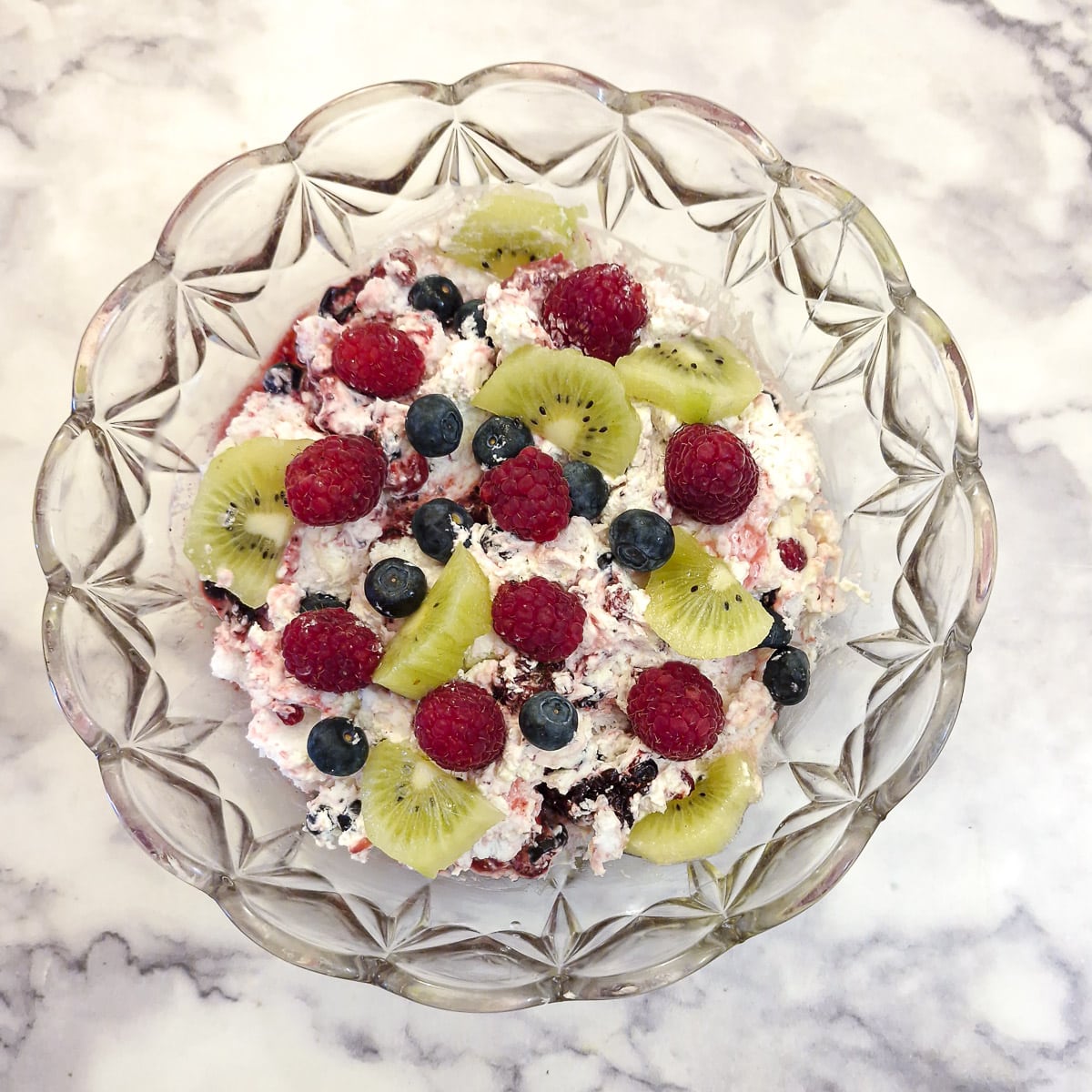 A fully assembled Eton mess decorated with pieces of fresh fruit.
