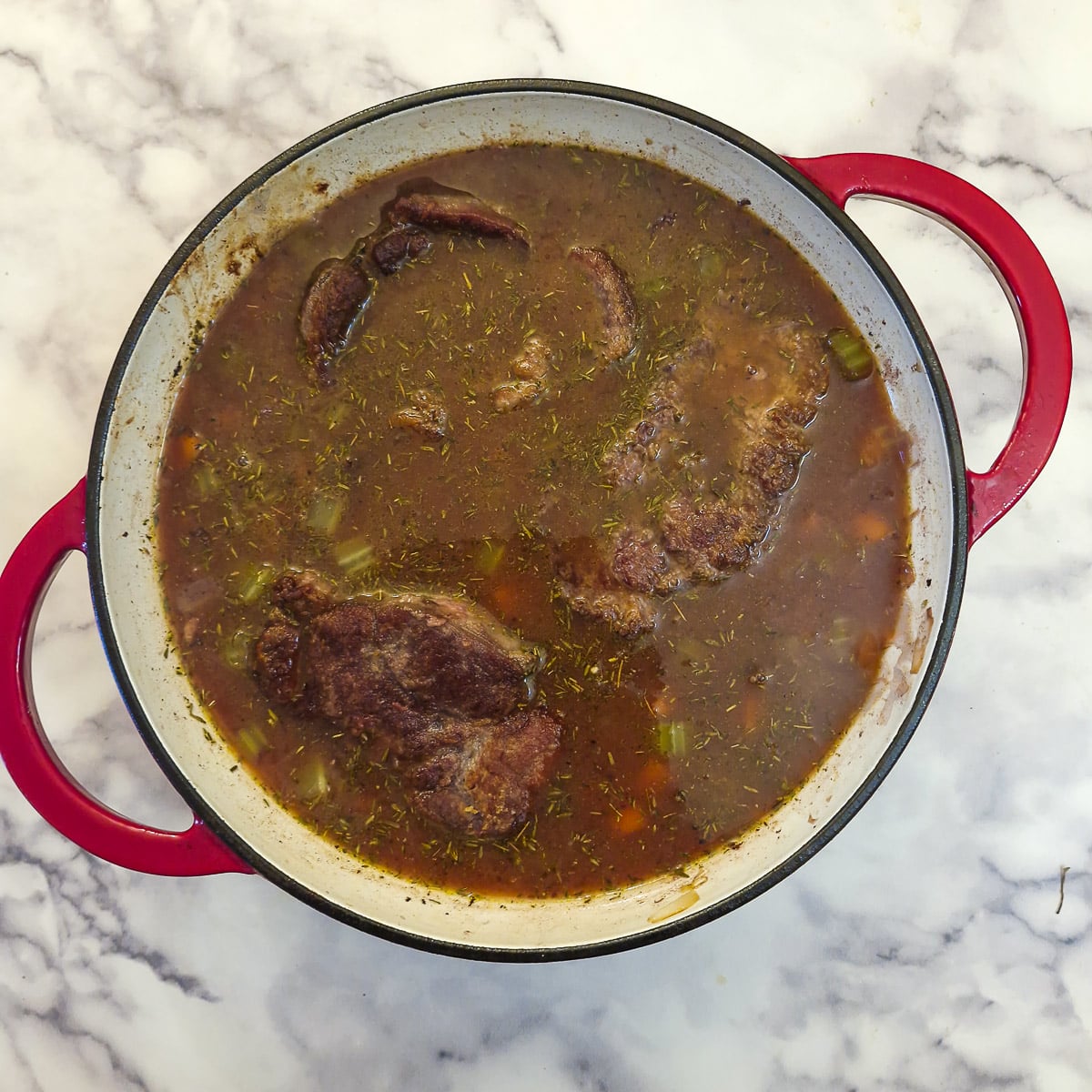 Beef shin and gravy in a casserole dish.