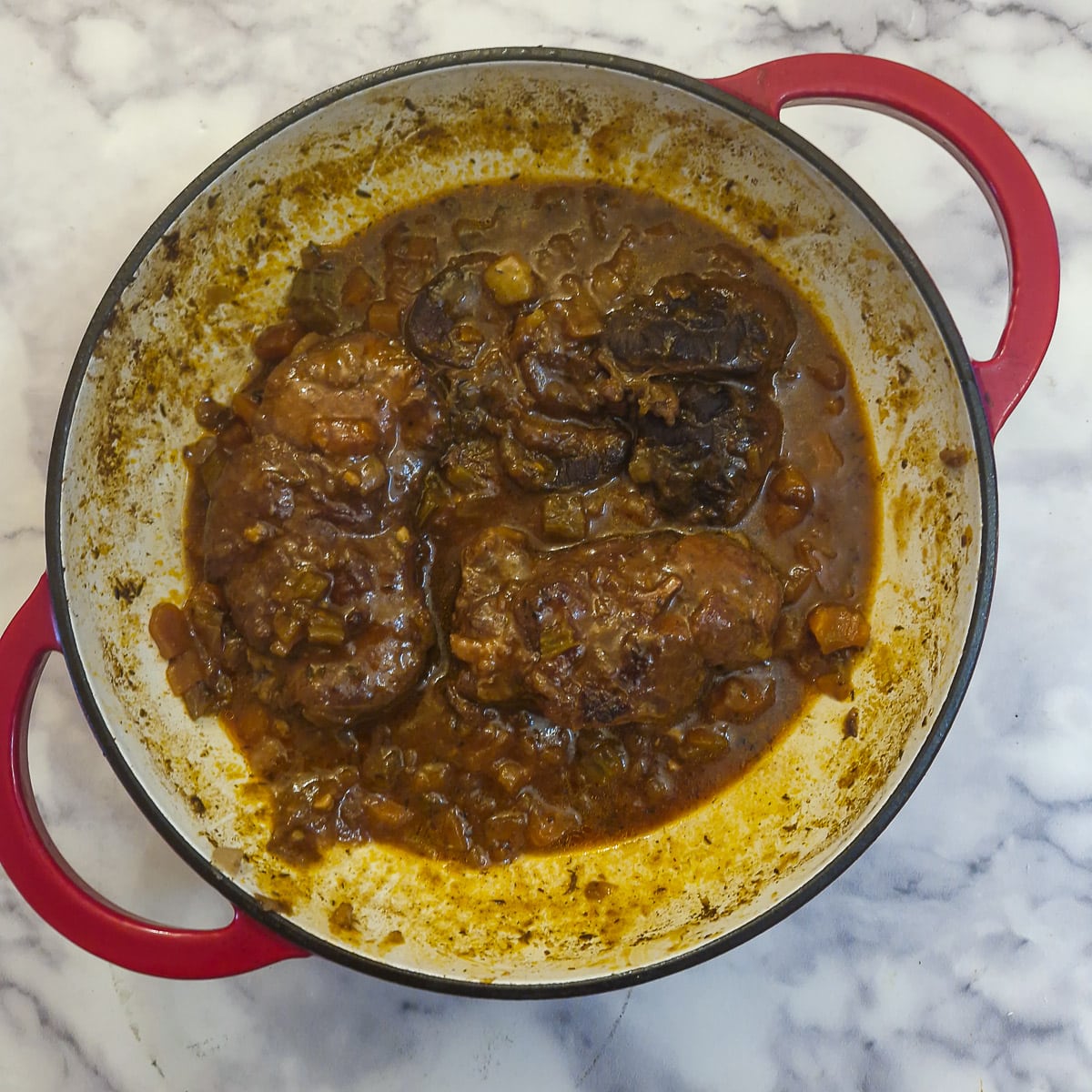  Fully cooked beef shin osso buco in a casserole dish.
