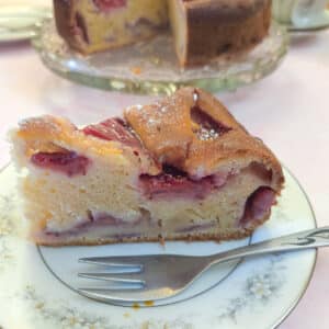 A slice of strawberry mascarpone cake on a blue patterned plate with a cake fork.