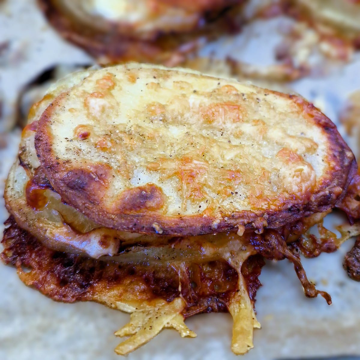 A close up of a cooked potato an onion slice.