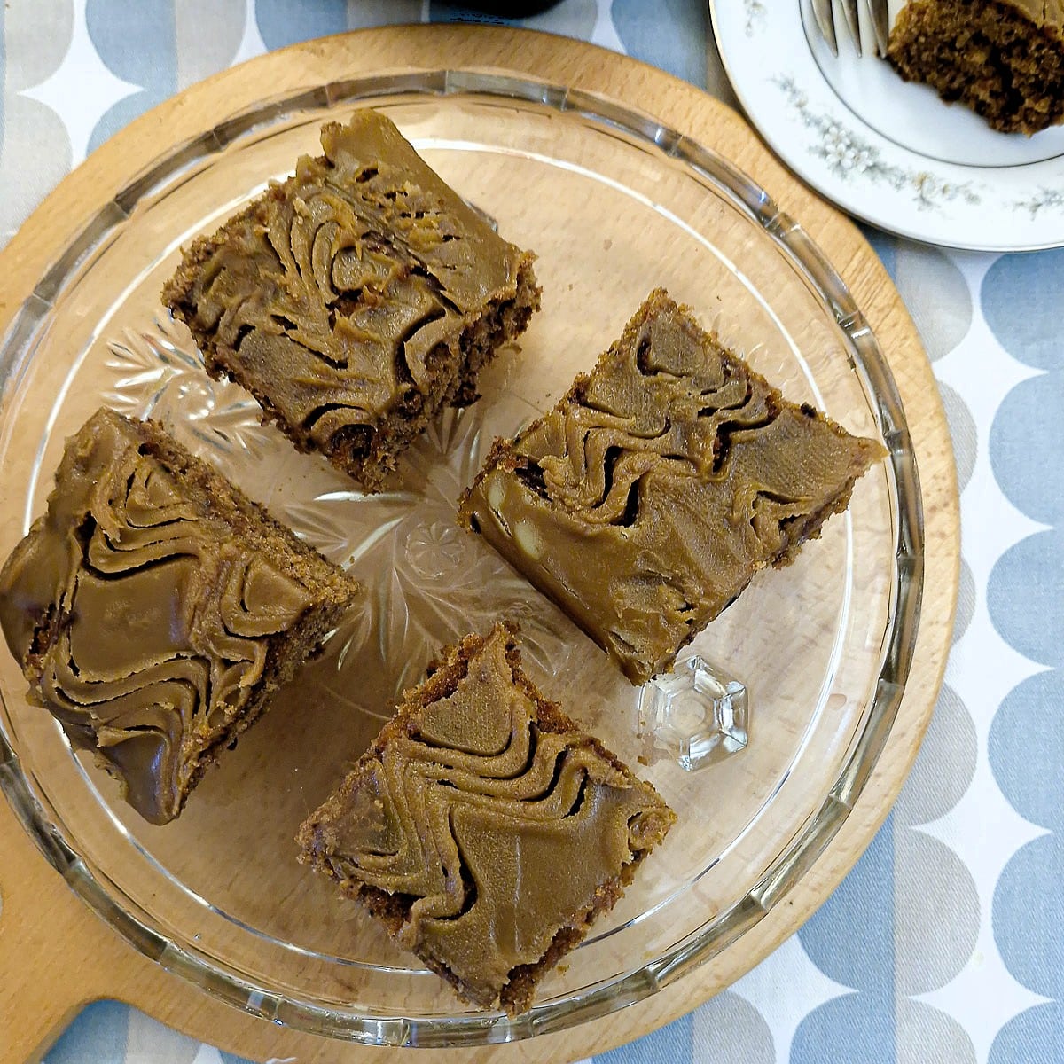 4 slice3s of sticky toffee traybake cake on a glass platter.