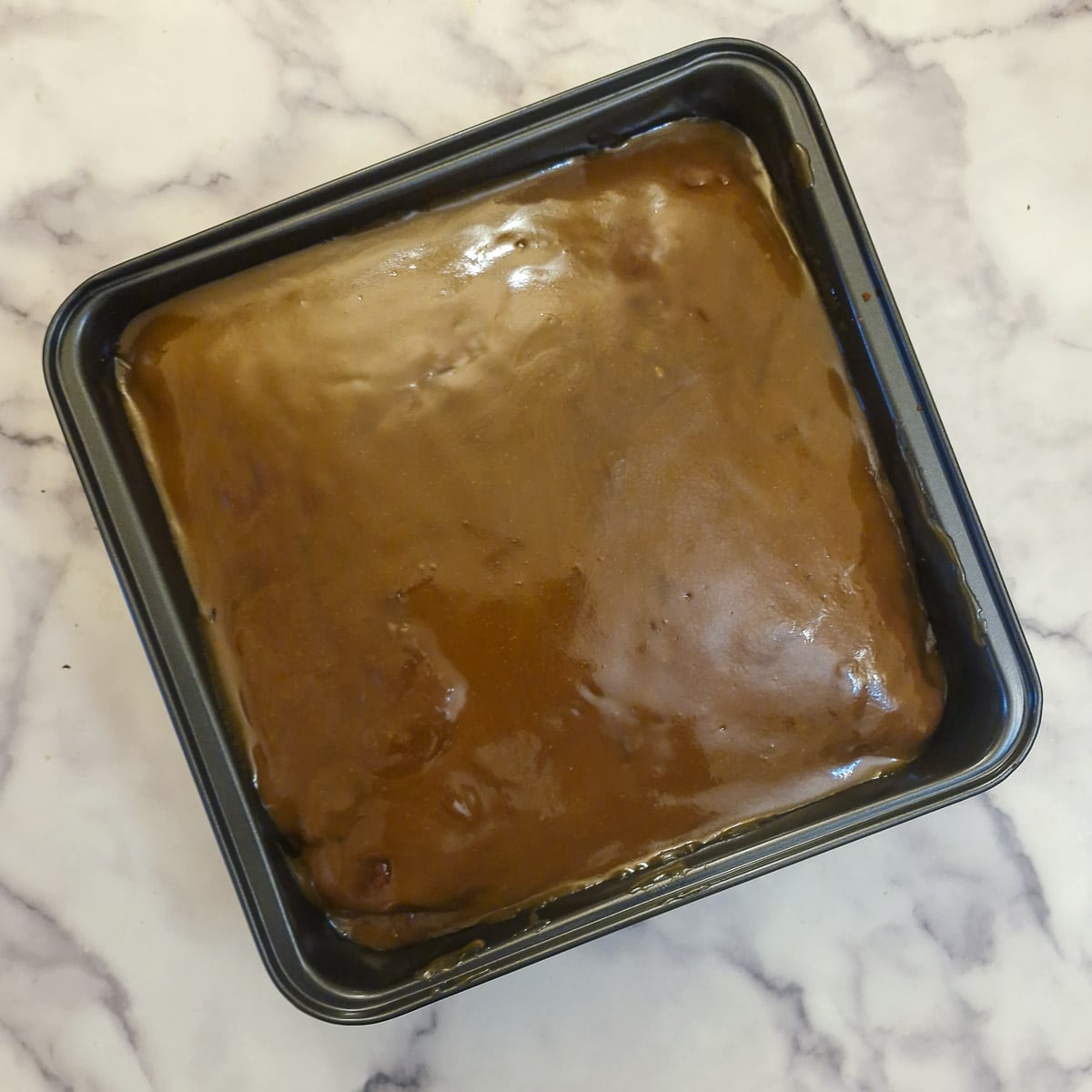 Toffee sauce poured over the cake (still in a baking tray).