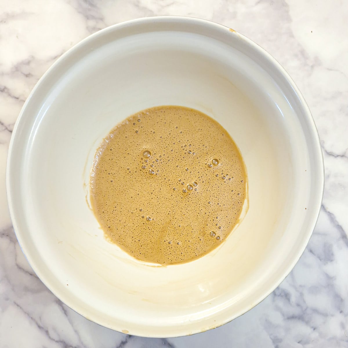 Eggs and brown sugar combined in a large mixing bowl.