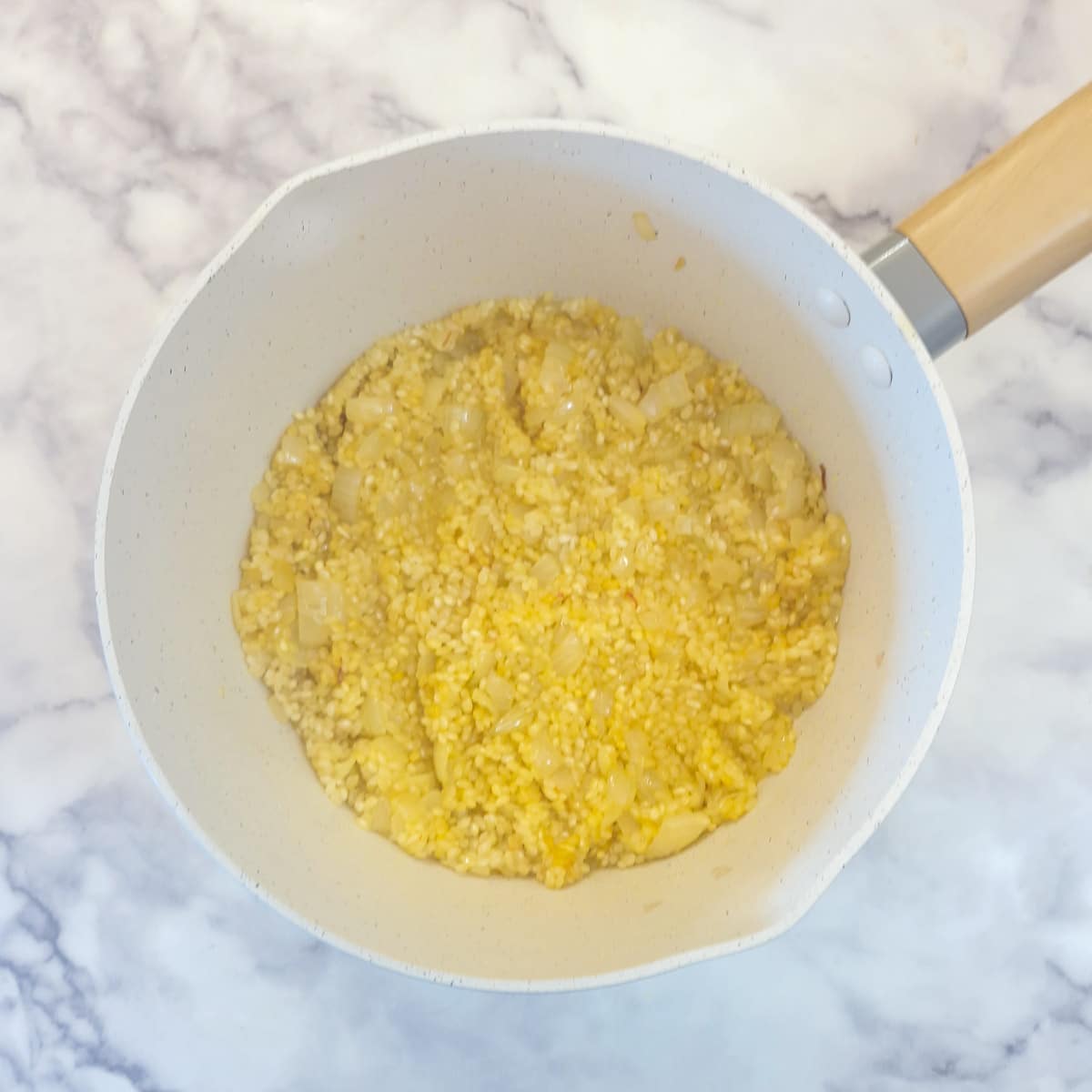 Vinegar mixture being combined with rice and onions.