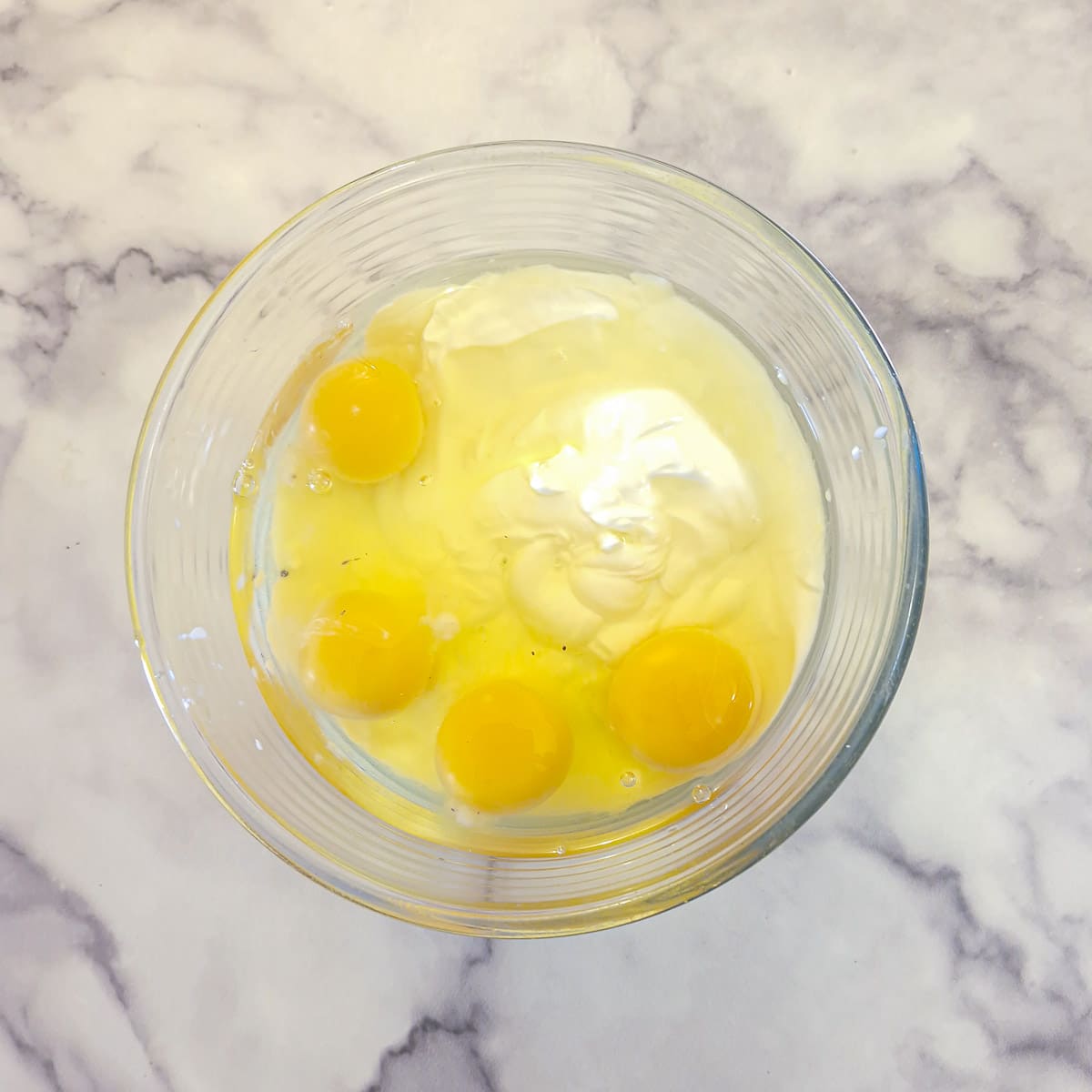 Step 1, place the yoghurt and eggs into a mixing bowl.