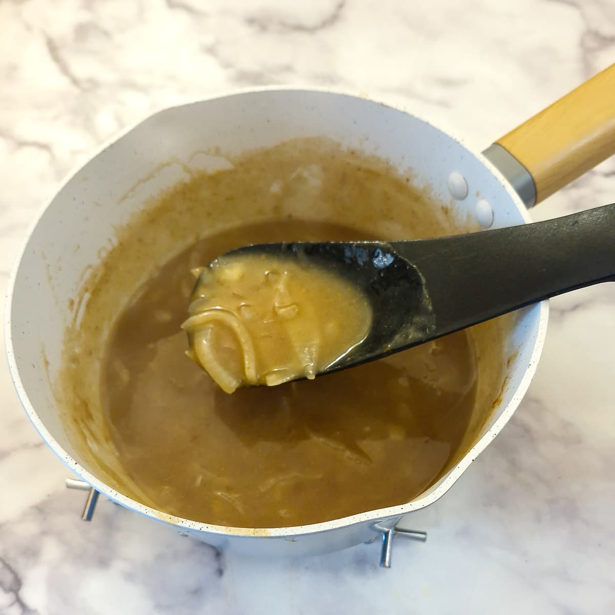 Step 7, onion gravy boiled and thickened in a saucepan.